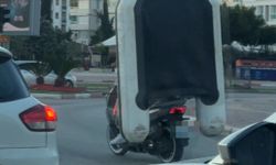Motosiklet üzerinde şişme botla tehlikeli yolculuk