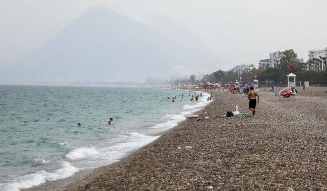 Antalya'da yağmura aldırmadan yüzmeye devam ettiler