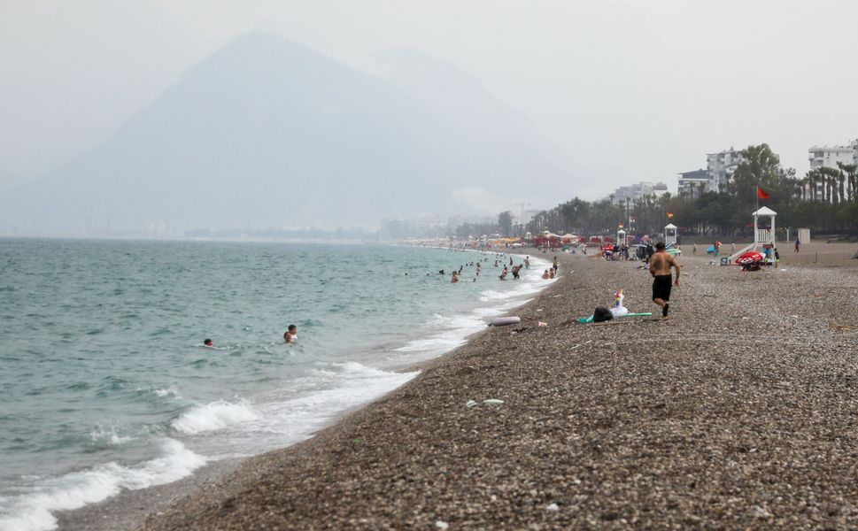 Antalya'da yağmura aldırmadan yüzmeye devam ettiler